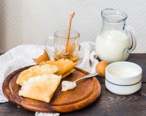 thin pancakes with cottage cheese, prunes, honey and sour cream