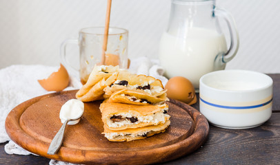 thin pancakes with cottage cheese, prunes, honey and sour cream