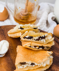 thin pancakes with cottage cheese, prunes, honey and sour cream