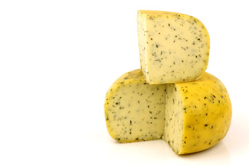 cut traditional Gouda cheese with herbs on a white background