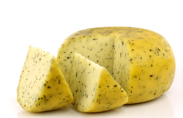 cut traditional Gouda cheese with herbs on a white background