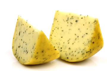 cut traditional Gouda cheese with herbs on a white background