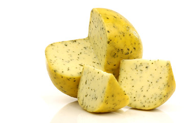 cut traditional Gouda cheese with herbs on a white background