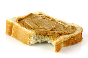 sliced white bread with peanut butter on a white background