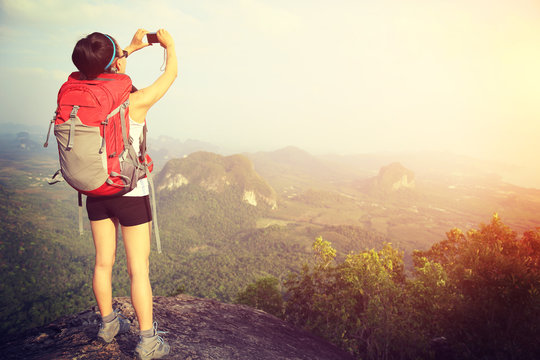 woman hiker  use smart phone taking photo mountain peak 