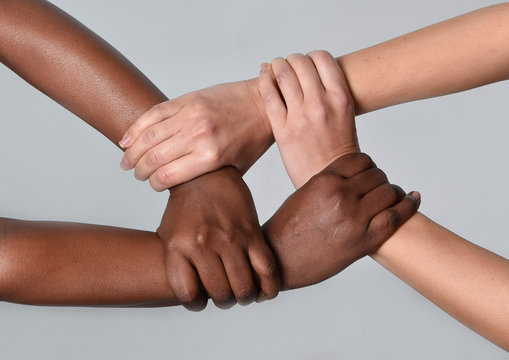 Caucasian and black African hands together against racism