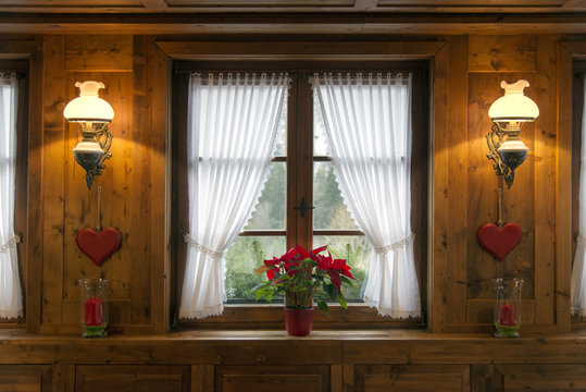 Romantic window with sconces and wooden paneling