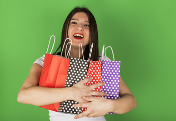 Happy young girl with spotty bags in studio