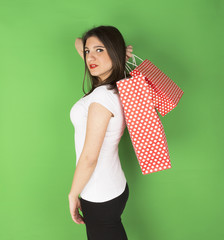 Happy young girl with spotty bags in studio