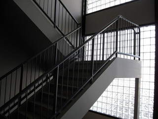 An up staircase in front of a glass-block wall.