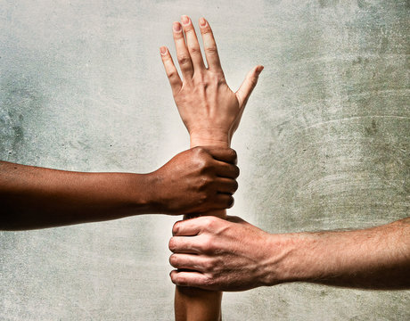 African American and Caucasian hands together world unity