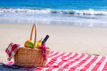 Picnic basket with fruits by the ocean - 78659119