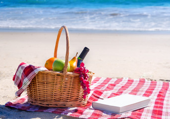 Picnic basket with fruits by the ocean