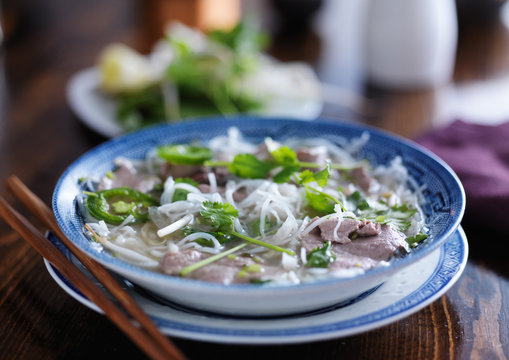 pho in a bowl with beef slices and noodles