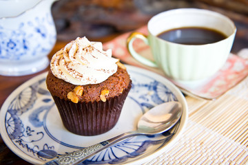 Hot coffee with chocolate cup cake on wooden table