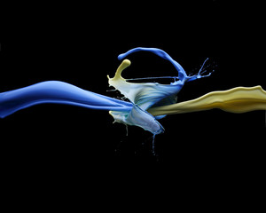 splash blue and yellow paint on a black background