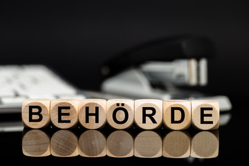 Behörde - Würfel vor Büromaterial