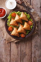 samosa on a plate with sauce on a plate , vertical top view © FomaA