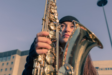 Beautiful young woman with her saxophone