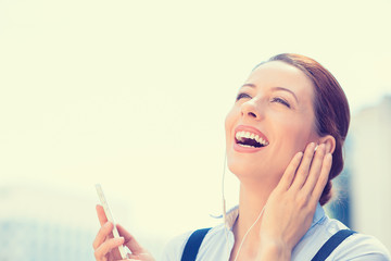 woman walking on street listening music on mobile smart phone