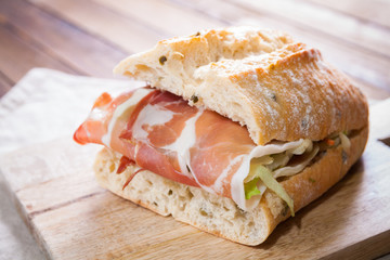 Sandwich with parma ham and salad on wooden cutting board - 78668176