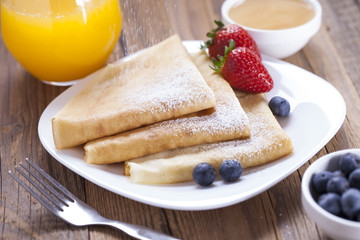 Delicious sweet French pancakes on a plate with fresh fruits