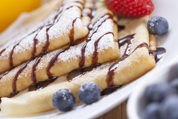 Delicious sweet French pancakes on a plate with fresh fruits