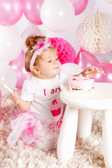 Fototapeta premium Baby eating the birthday cake with fingers