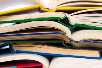 A stack of colorful, open books on a white background