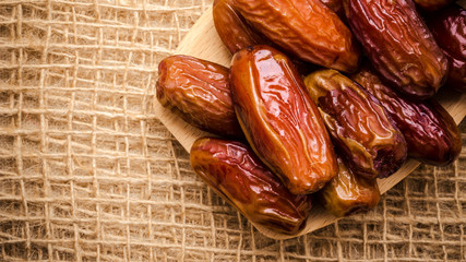 dried dates on wooden spoon cloth background