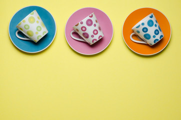 decorative espresso cups playfully lying on colorful plates