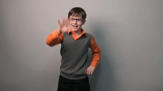 teenager boy dancing funny waving his arms in glasses ten years
