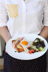 A servant is holding a plate with breakfast