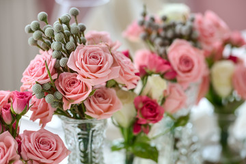 Bouquets of roses on a festive wedding table in the restaurant.