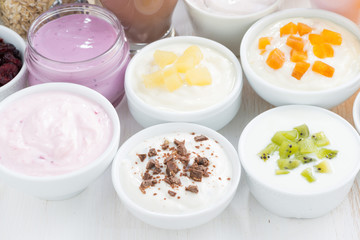 Fototapeta na wymiar Assorted fruit yoghurts and breakfast ingredients, close-up