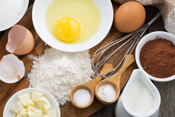 Baking ingredients on a wooden board, top view