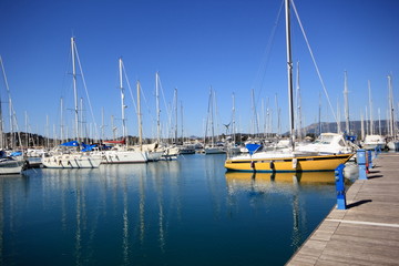 Fototapeta na wymiar Yachts and sail boats reflected in a Marina harbour
