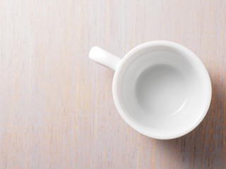 Empty white cup on wood texture background