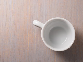 Empty white cup on wood texture background