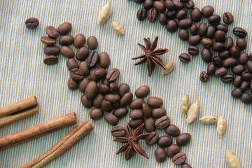 coffee and peaberry scattered on burlap with spices