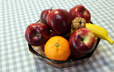 ripe red apples and fruit in the basket above the table