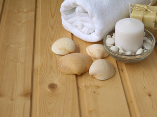 Towel,soap,candle and shells on the wooden background