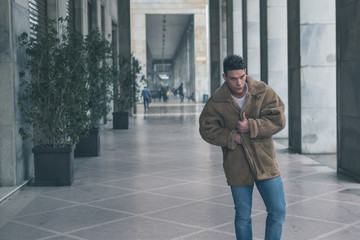 Young handsome man posing in the city streets