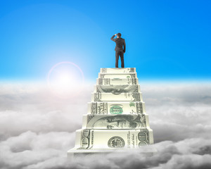 Businessman reaching the top of money stairs with sunlight cloud