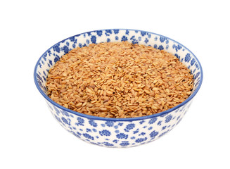 Golden linseed or flax seeds in a blue and white china bowl