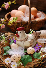 easter decoration of hen in the nest and wicker basket with eggs