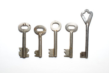 Five old keys to the safe on a white background