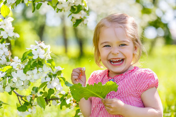 Happy little girl in spring sunny park