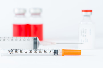 Disposable syringe and red cap of injection vial