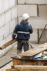 Bauarbeiter trägt Holzlatte